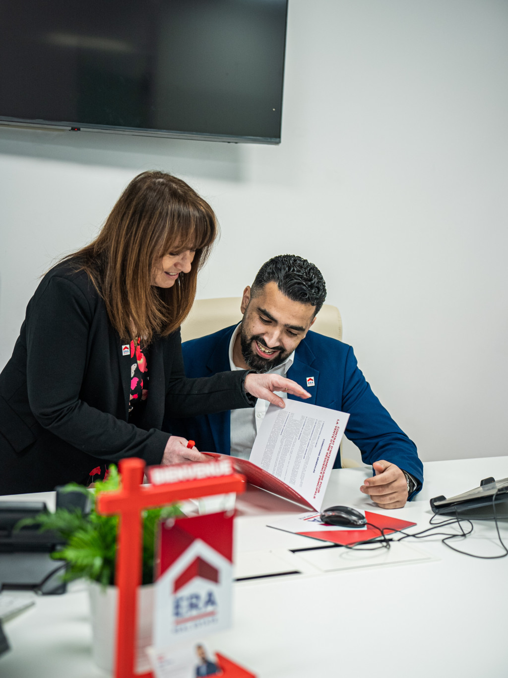 lachend-makelaars-aan-een-bureau