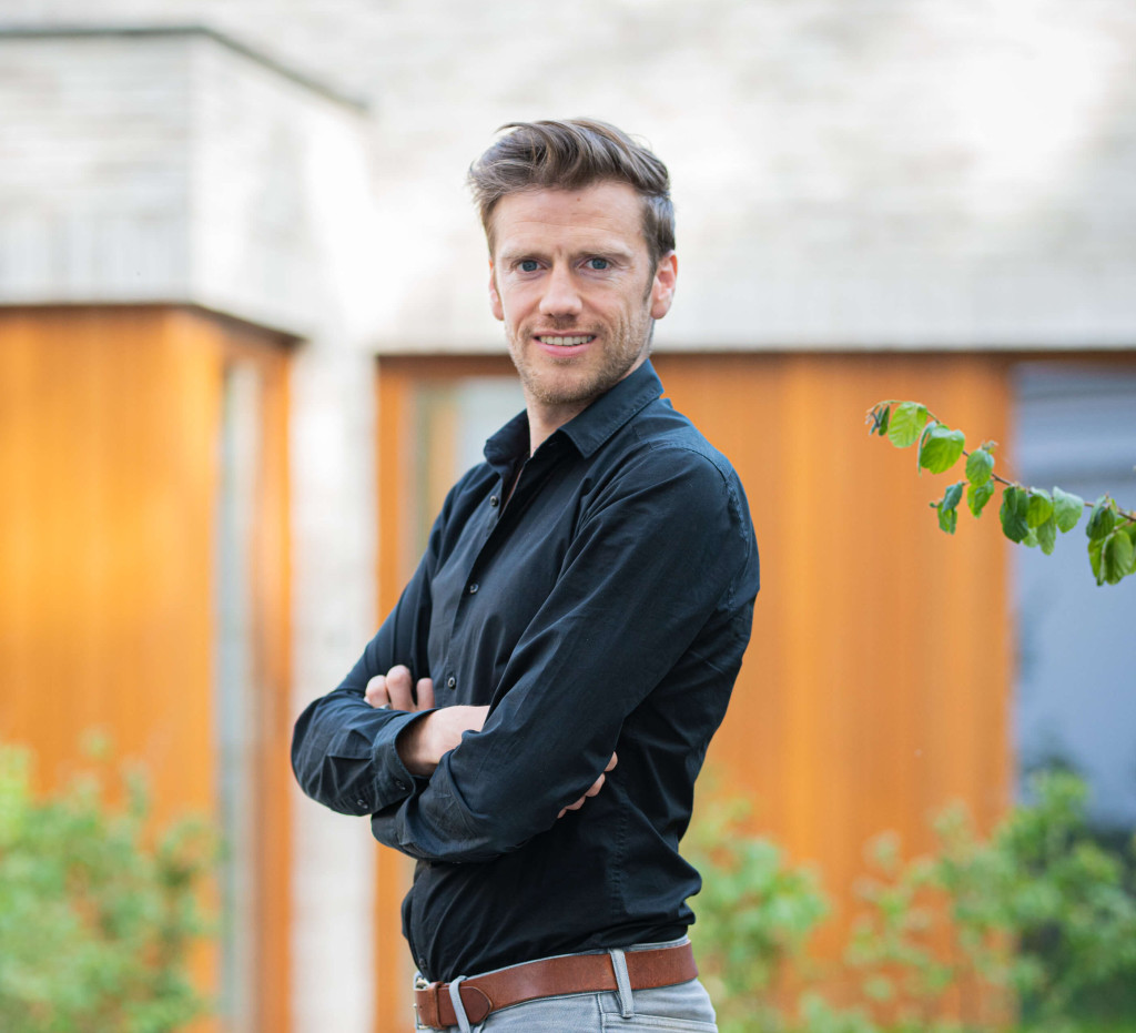 Topmakelaar Johan kijkt lachend in de camera.