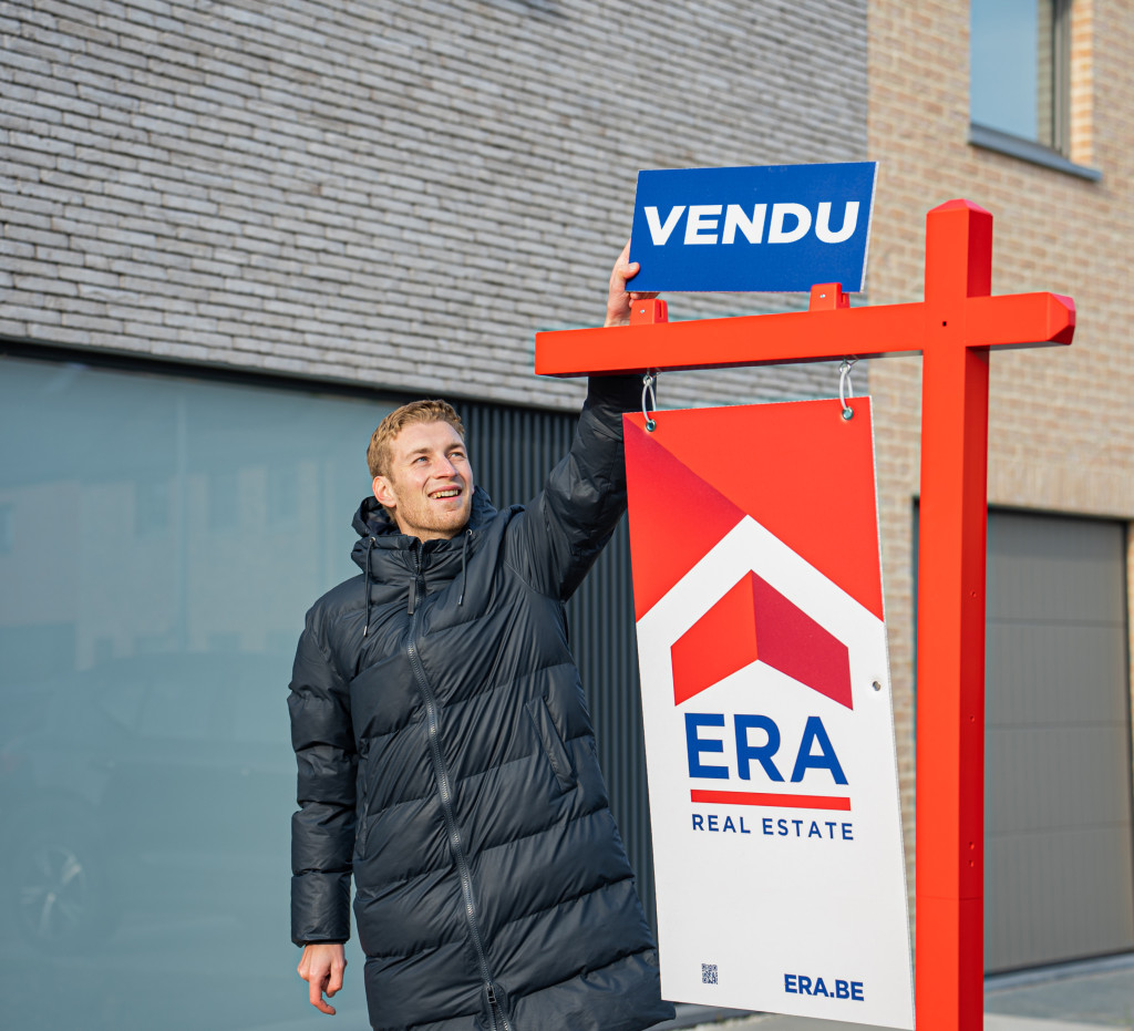 Agent immobilier ERA avec un panneau vendu