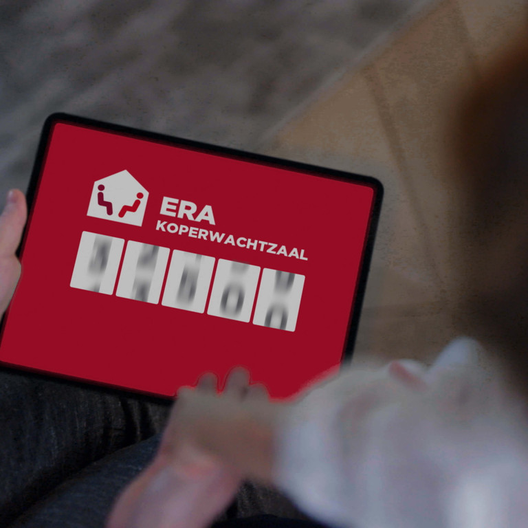 Twee personen bekijken de ERA Koperwachtzaal op een tablet.