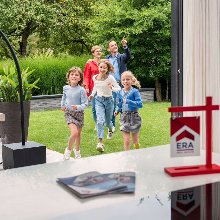 Een gezin komt een woning bezoeken, de kinderen lopen met drie heel enthousiast naar binnen.