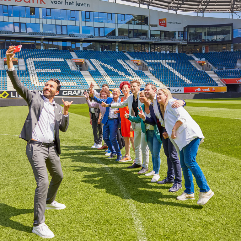 Alle Topmakelaars poseren samen voor een selfie.