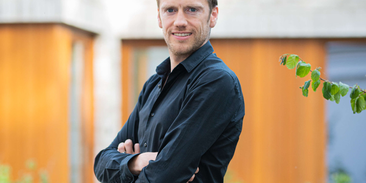 Topmakelaar Johan kijkt lachend in de camera.