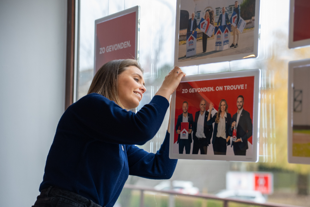 ERA makelaar bezig met de etalage.