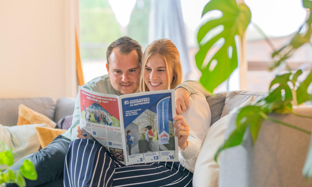 un couple lit le journal de la Journée Maisons Ouvertes de l'ERA